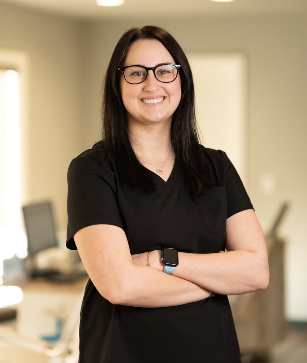 Smiling woman in black with Invisalign at Scissortail Orthodontics.